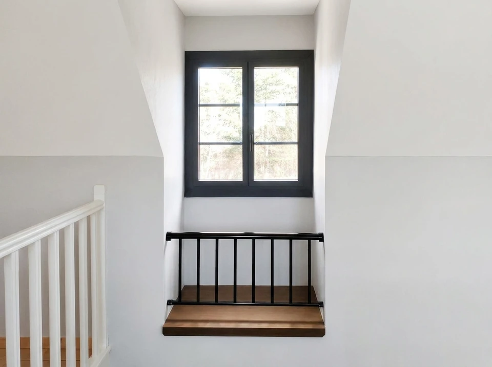 Cage d'escalier moderne avec fenêtre double battant à châssis anthracite, vue depuis le palier supérieur
