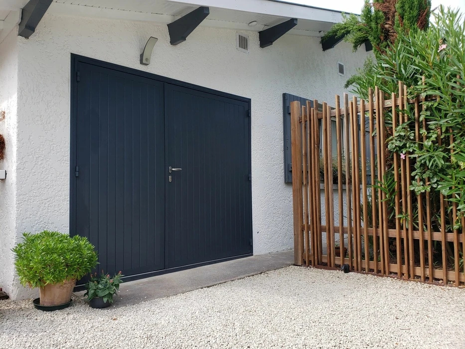 Porte de garage sectionnelle grise avec portillon intégré, finition lisse horizontale