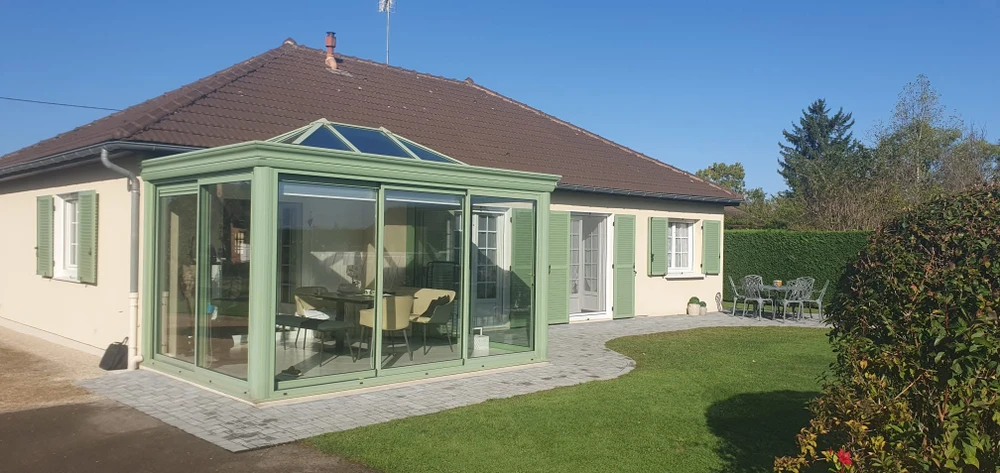 Véranda contemporaine en aluminium anthracite, installée en étage sur une terrasse bétonnée